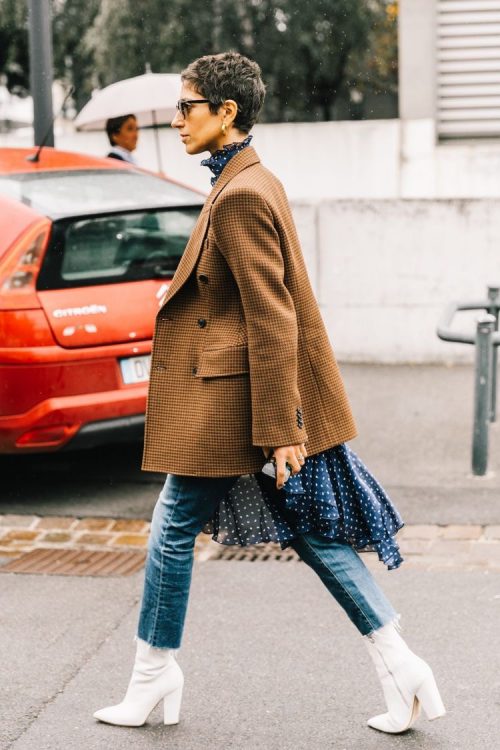 Mujer caminandopor la calle con un abrigo y jeans rectos